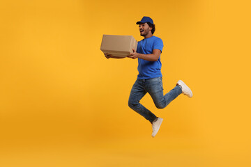 Happy courier with parcel jumping on orange background, space for text