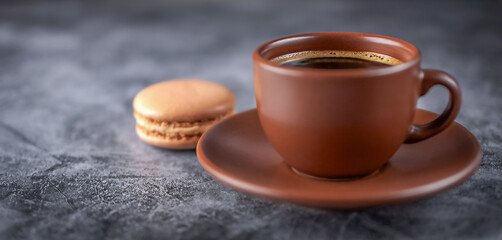 Coffee in a brown cup on a table in a cafe on a gray background
