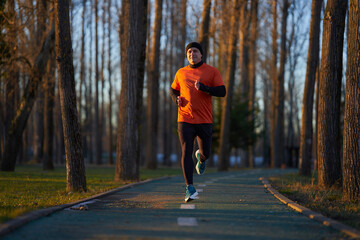Obraz premium Man running in the park in wintertime