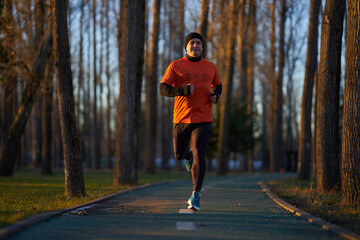 Obraz premium Man running in the park in wintertime