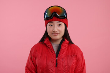 Beautiful woman in winter sportswear on pink background