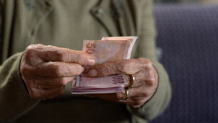 old woman counting money on hand