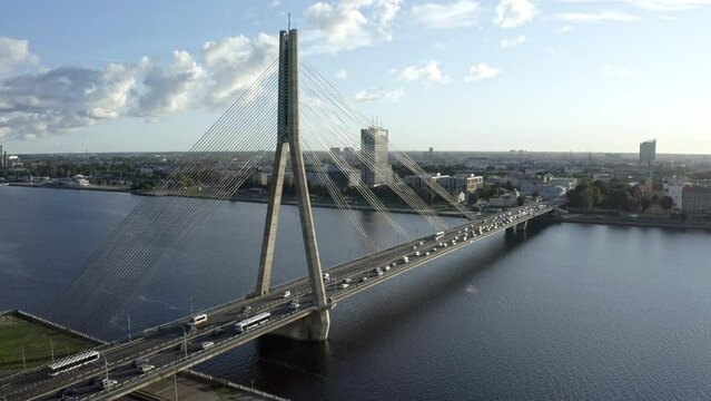 Traffic on Vansu Bridge over Daugava river in Riga city center, aerial view with scenic clouds