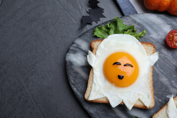 Halloween themed breakfast served on black table, flat lay and space for text. Tasty toast with...