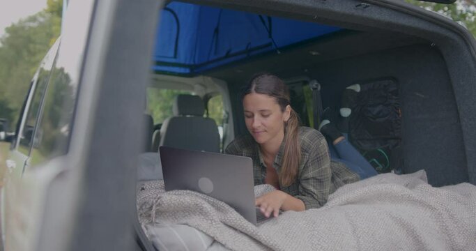 Female Working on Laptop in Campervan on Road trip