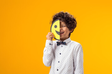 Happy boy holding happy and sad faces on two pieces of memo paper. emoticon. - obrazy, fototapety, plakaty