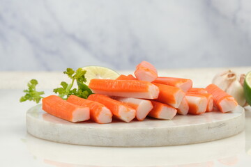 fresh crab sticks with lemon on white table © ROHE Creative Studio