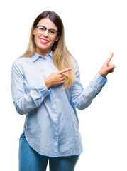 Young beautiful business woman wearing glasses over isolated background smiling and looking at the camera pointing with two hands and fingers to the side.