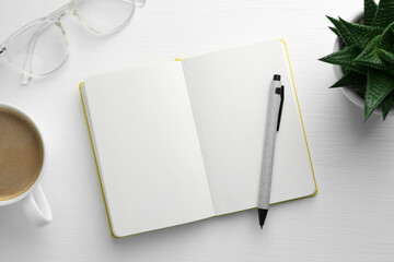 Open notebook, pen, glasses, succulent and cup of coffee on white wooden table, flat lay. Space for text
