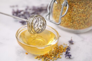 Fresh honey in bowl, dipper, bee pollen granules and lavender on light table, closeup