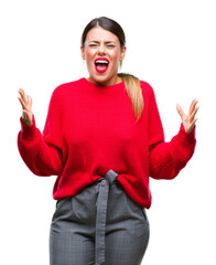 Young beautiful business woman wearing winter sweater over isolated background crazy and mad shouting and yelling with aggressive expression and arms raised. Frustration concept.
