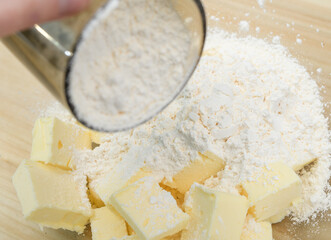 Mąka dodawana do składników na kruche ciasto w szklanej misce  - obrazy, fototapety, plakaty