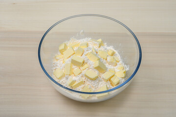 Robić kruszonkę do ciasta, w misce mąka i pokrojone w kostkę masło 