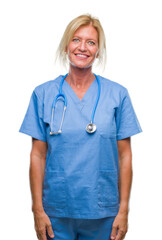 Middle age blonde nurse surgeon doctor woman over isolated background with serious expression on...