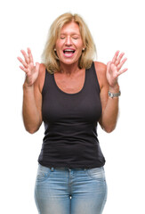Fototapeta na wymiar Middle age blonde woman over isolated background crazy and mad shouting and yelling with aggressive expression and arms raised. Frustration concept.