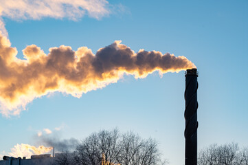 Big chimney with lots of smoke and clear blue sky