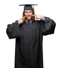 Young handsome graduated man with long hair over isolated background smiling confident showing and pointing with fingers teeth and mouth. Health concept.