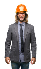 Young handsome architec man with long hair wearing safety helmet over isolated background with a happy and cool smile on face. Lucky person.