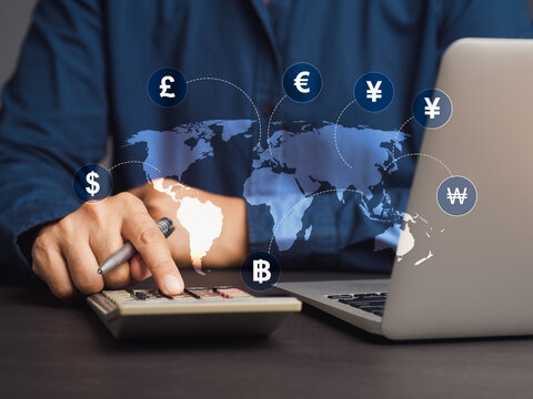 Businessman uses a calculator to calculate currency exchange while sitting at a desk in the office.