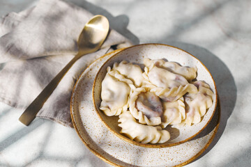 Dumplings with cherries with sour cream and sugar. Traditional dish of Russian, Ukrainian, Belarusian cuisine known as Vareniki