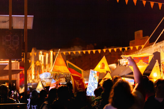 Crowds holding lantern lights above heads during multicultural event celebration