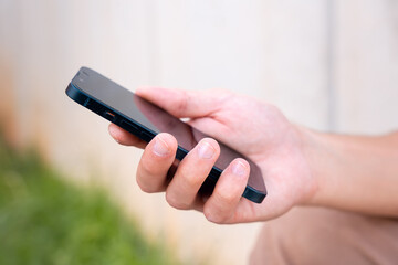  close up of young boy using smartphone app outdoors.