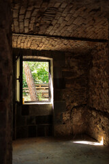 Fototapeta na wymiar stone basement in an old house during restoration. An open window to the garden.