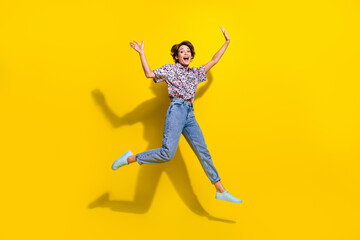 Fototapeta na wymiar Full body portrait of energetic astonished lovely lady jumping raise hands isolated on yellow color background