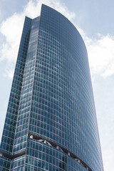 A tall glass business building with large windows. Architecture