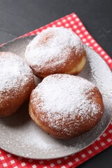 Delicious sweet buns with powdered sugar on table, closeup