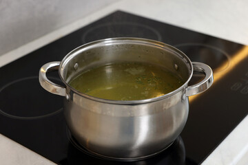 Pot with tasty soup on cooktop in kitchen