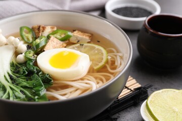 Bowl of vegetarian ramen on grey table, closeup