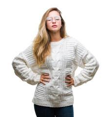 Young beautiful blonde woman wearing winter sweater and sunglasses over isolated background winking...