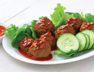 Indonesian spicy sauce meat balls with lettuce and cucumber