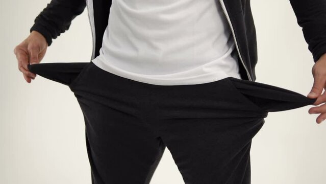 The man takes out the empty pockets of his sports pants and starts to dance. Empty pockets of poor sportsman. The player lost everything, but he does not get upset. The thing is lost from the pocket.
