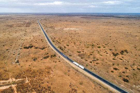 Aerial view of two trucks on Eyre Highway along the Nullarbor Plain