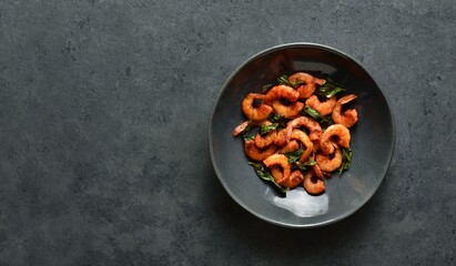 Roasted shrimp with basil leaves in bowl