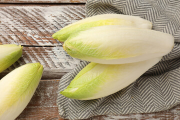 Fresh raw Belgian endives (chicory) on wooden table, top view