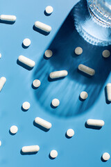 Various vitamins and pills on a blue background. Medicine, treatment and health.