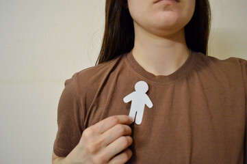 Girl holding paper man on her chest. Day for the Abolition of Slavery. World Day Against the Death...