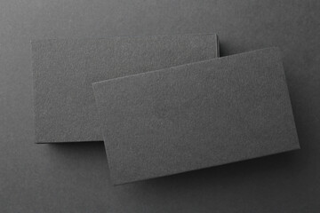 Blank business cards on black background, top view. Mockup for design