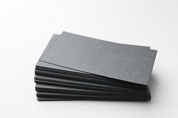 Blank black business cards on white table, closeup. Mockup for design