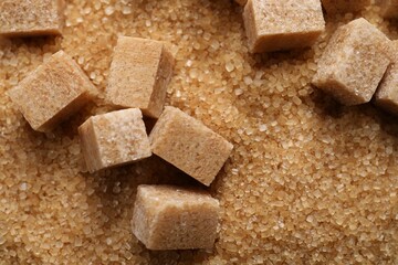 Different types of brown sugar as background, top view