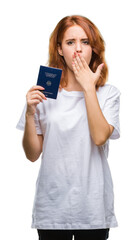 Fototapeta premium Young beautiful woman holding passport of germany over isolated background cover mouth with hand shocked with shame for mistake, expression of fear, scared in silence, secret concept