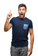 Naklejka premium Young handsome man over isolated background pointing finger up with successful idea. Exited and happy. Number one.