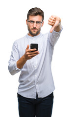 Young handsome man texting using smartphone over isolated background with angry face, negative sign showing dislike with thumbs down, rejection concept