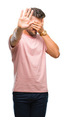 Naklejka premium Young handsome man over isolated background covering eyes with hands and doing stop gesture with sad and fear expression. Embarrassed and negative concept.