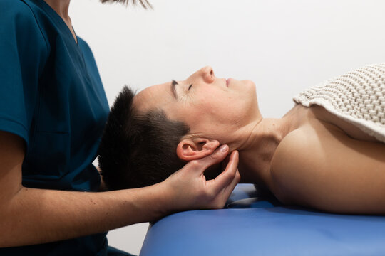 Chiropractor performing neck adjustment on patient