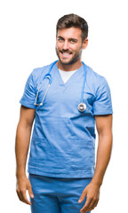 Young handsome doctor surgeon man over isolated background looking away to side with smile on face, natural expression. Laughing confident.