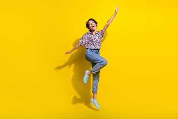 Fototapeta na wymiar Full body photo of cheerful lovely lady raise arms jump fly have good mood isolated on yellow color background